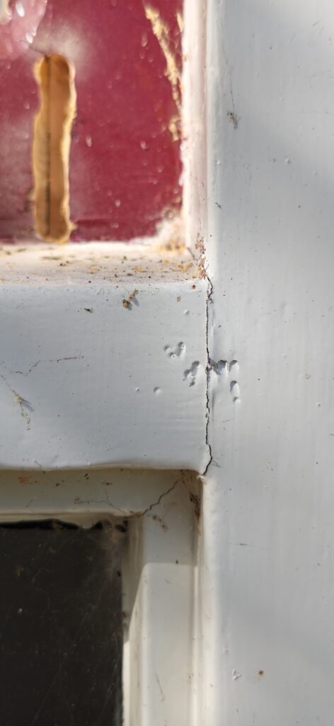 Haarscheur in verflaag op kozijnhoek als eerste signaal van houtrot